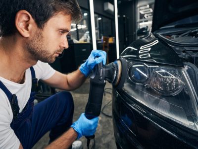 automobile-headlight-grinded-by-mechanic-with-polisher.jpg